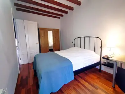 a bedroom with a white bed and a wooden floor at VL51 in Barcelona