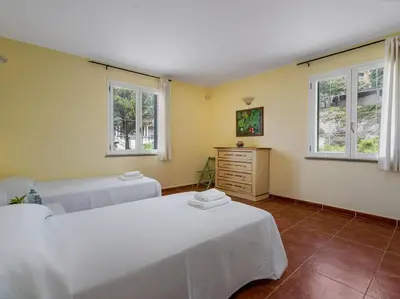 a bedroom with two beds and two windows at Architectural jewel between sea and mountains in Teià