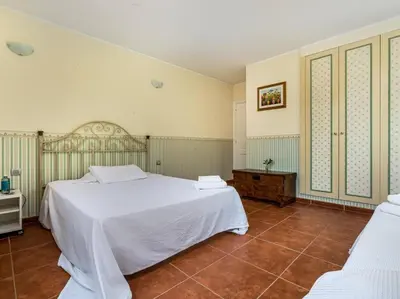 a bedroom with a large white bed and a tile floor at Architectural jewel between sea and mountains in Teià