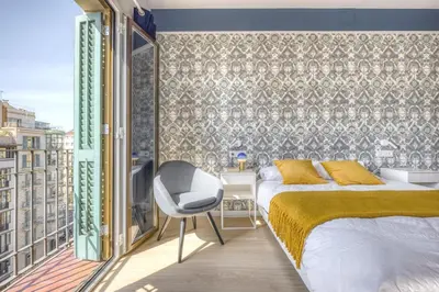 a bedroom with a bed and a chair on a balcony at Stay U-nique Apartments Rambla Catalunya III in Barcelona
