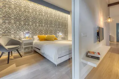 a bedroom with a bed and a chair and a tv at Stay U-nique Apartments Rambla Catalunya III in Barcelona