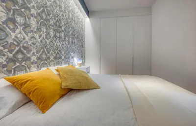 a bedroom with a bed with a yellow pillow on it at Stay U-nique Apartments Rambla Catalunya III in Barcelona