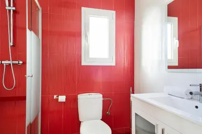 a red bathroom with a toilet and a sink at Stay U-nique Apartments Rambla Catalunya IV in Barcelona