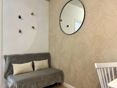 a mirror on a wall next to a couch at Stay U-nique Apartments Rambla Catalunya V in Barcelona