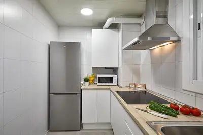 a kitchen with a refrigerator and some vegetables on the counter at BBarcelona Central Eixample Flat in Barcelona