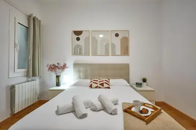 a bedroom with a white bed with towels on it at BBarcelona Central Eixample Flat in Barcelona