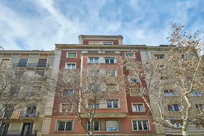 a tall brick building with trees in front of it at BBarcelona Central Eixample Flat in Barcelona