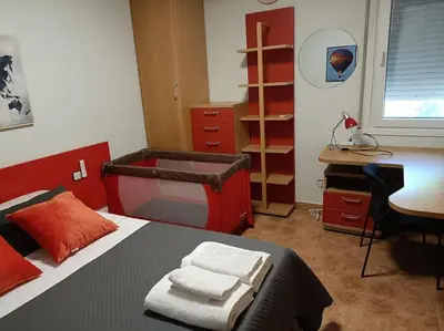 a bedroom with a red bed with a desk and a desk at Casa con jardín y piscina privada. in Santa Eulalia de Ronsaná