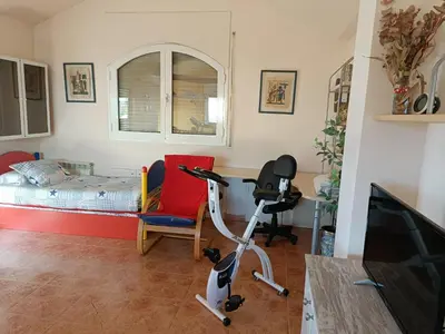 a room with a bedroom with a bed and a desk at Casa con jardín y piscina privada. in Santa Eulalia de Ronsaná