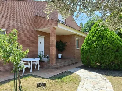 a house with a table and chairs on a patio at Casa con jardín y piscina privada. in Santa Eulalia de Ronsaná