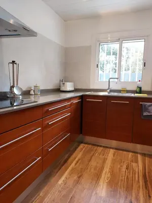 a kitchen with wooden cabinets and a sink at Cerca de Barcelona, y entre tres Parques Naturales, casa de 4 habitaciones y 2 baños con piscina, barbacoa y chimenea in San Antonio de Vilamajor