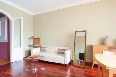 a living room with a white couch and a mirror at Ático con encanto, centro, con aparcamiento in Barcelona