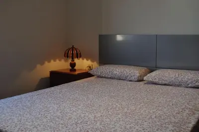 a bedroom with a bed and a lamp on a table at Ático con encanto, centro, con aparcamiento in Barcelona