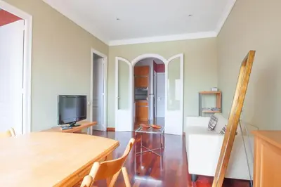 a living room with a table and a tv at Ático con encanto, centro, con aparcamiento in Barcelona