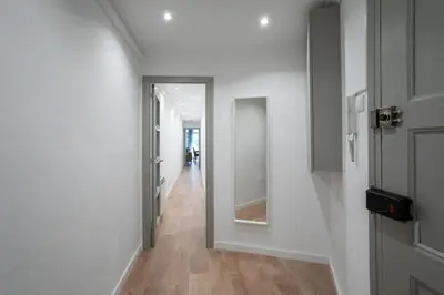 a hallway with white walls and wooden floors and a door at Canela Homes BARCELONA PADILLA in Barcelona
