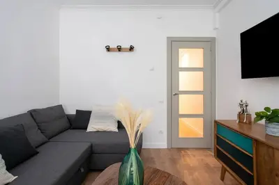 a living room with a gray couch and a vase with feathers at Canela Homes BARCELONA PADILLA in Barcelona