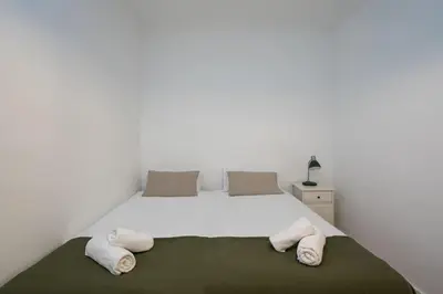 a bedroom with a large white bed with towels on it at Canela Homes BARCELONA PADILLA in Barcelona