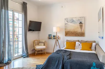 a bedroom with a bed with yellow pillows and a tv at Canela Homes BARCELONA FIRA in Barcelona