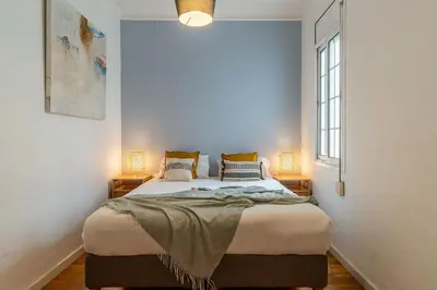 a bedroom with a large bed with two lamps at Canela Homes BARCELONA FIRA in Barcelona