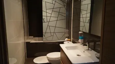 a bathroom with a sink and a toilet and a mirror at Good-Home Paseo de Gracia in Barcelona