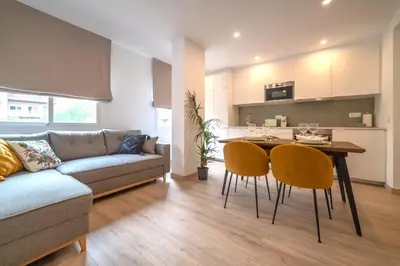 a living room with a couch and a table and chairs at Soler Apartments in Sant Adria de Besos