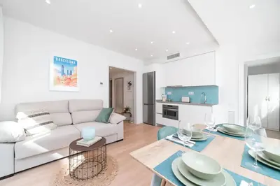 a living room with a white couch and a table at Soler Apartments in Sant Adria de Besos