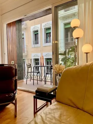 a living room with a couch and a view of a balcony at Stunning Designer 2 Bed Apt in Glorious Gràcia in Barcelona