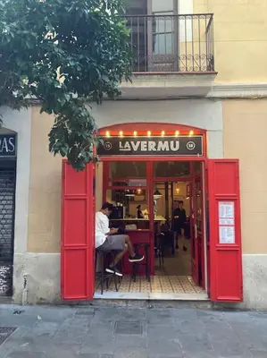 a red doorway to a restaurant with a man sitting at a table at Stunning Designer 2 Bed Apt in Glorious Gràcia in Barcelona