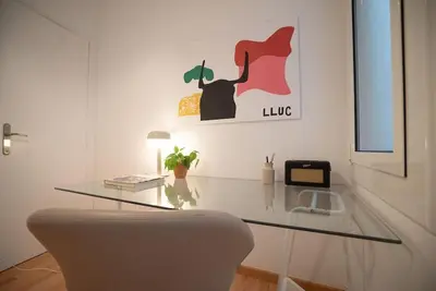 a glass table with a chair and a lamp in a room at Stunning Designer 2 Bed Apt in Glorious Gràcia in Barcelona