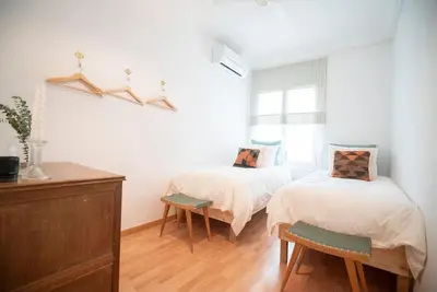 a bedroom with two beds and a window at Stunning Designer 2 Bed Apt in Glorious Gràcia in Barcelona