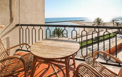 a wooden table and chairs on a balcony with the beach at 4 Bedroom Lovely Apartment In Cunit in Cunit