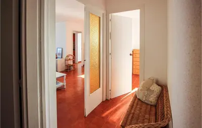 a room with a hallway with a chair and a door at 4 Bedroom Lovely Apartment In Cunit in Cunit