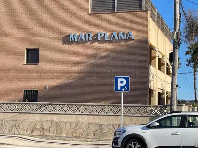 a white car parked in front of a brick building at MarPlana in Castelldefels
