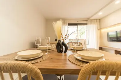 a dining room with a wooden table and chairs at MarPlana in Castelldefels