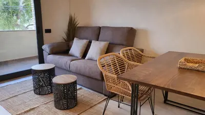 a living room with a couch and a table and chairs at MarPlana in Castelldefels
