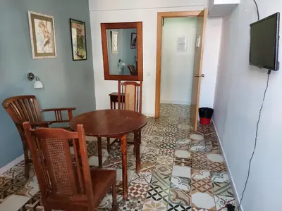 a dining room with a table and chairs and a television at Alberg Sants Bcn in Barcelona
