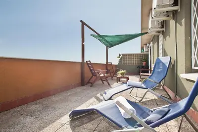a patio with chairs and a hammock on a balcony at Stay U-nique Apartments Marina III in Barcelona