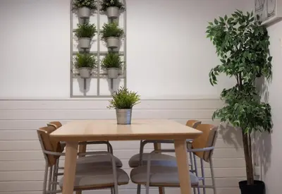 a table and chairs with potted plants on a wall at Stay U-nique Apartments Granados in Barcelona