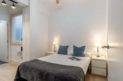 a bedroom with a large white bed with blue pillows at 1690 - AB Eixample Rosselló in Barcelona