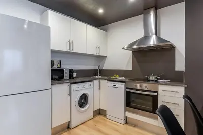 a kitchen with white cabinets and a washer and dryer at 1690 - AB Eixample Rosselló in Barcelona