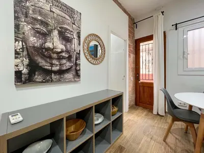 a living room with a painting of a face on the wall at Stay U-nique Apartments Caminal in Barcelona