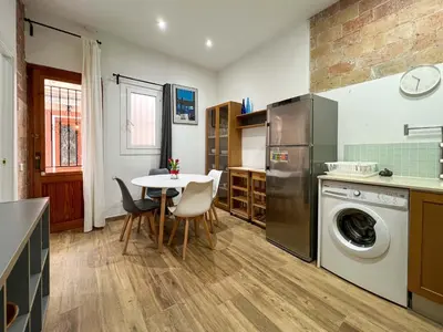 a kitchen with a table and a washing machine at Stay U-nique Apartments Caminal in Barcelona