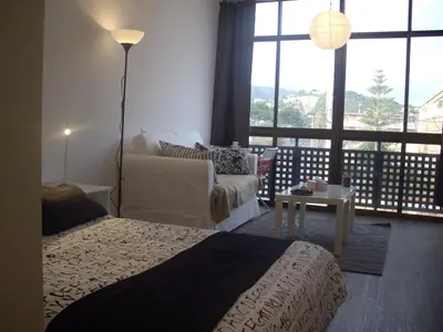 a bedroom with a bed and a couch and a living room at Beach Castelldefels in Castelldefels