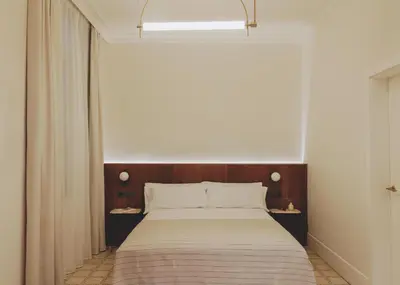 a bedroom with a large bed with a wooden headboard at Casa Llimona Hotel Boutique in Barcelona