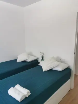 a bed with white pillows and towels on it at Ático in Terrassa