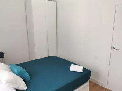 a room with a bed with blue pillows at Ático in Terrassa