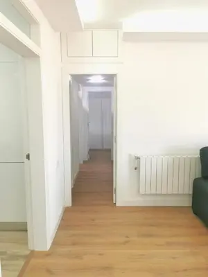a hallway with white walls and a wooden floor at Ático in Terrassa
