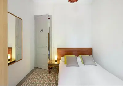 a bedroom with a white bed and a mirror at Great apartment in Sagrada Familia with Balcony in Barcelona