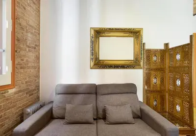 a living room with a couch and a mirror at Great apartment in Sagrada Familia with Balcony in Barcelona