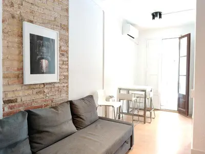 a living room with a couch and a brick wall at Family apartment Gracia in Barcelona